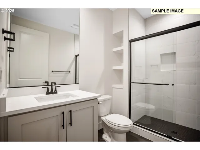 a bathroom with a sink a toilet a mirror and shower