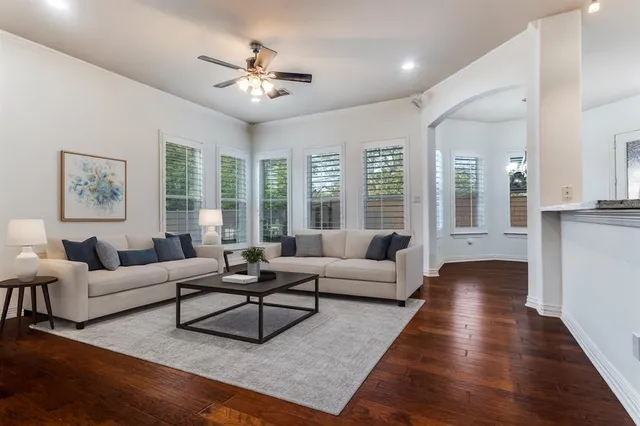 an empty room with wooden floor a kitchen view and a fireplace