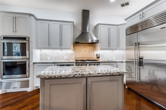 a view of kitchen with kitchen island wooden cabinets and refrigerator