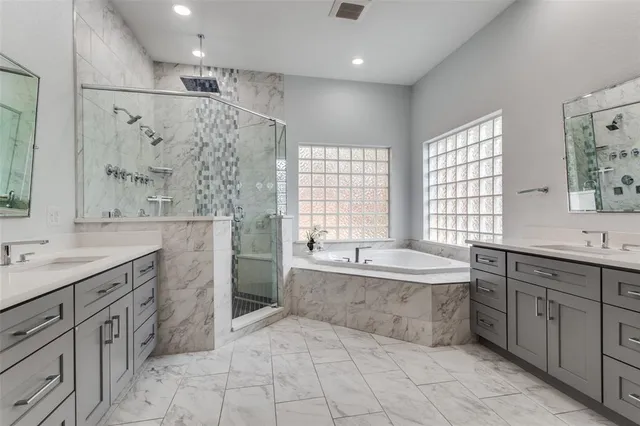 a large bathroom with a tub sink shower and mirror