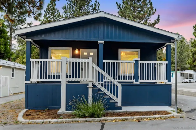 a view of a house with wooden deck and furniture