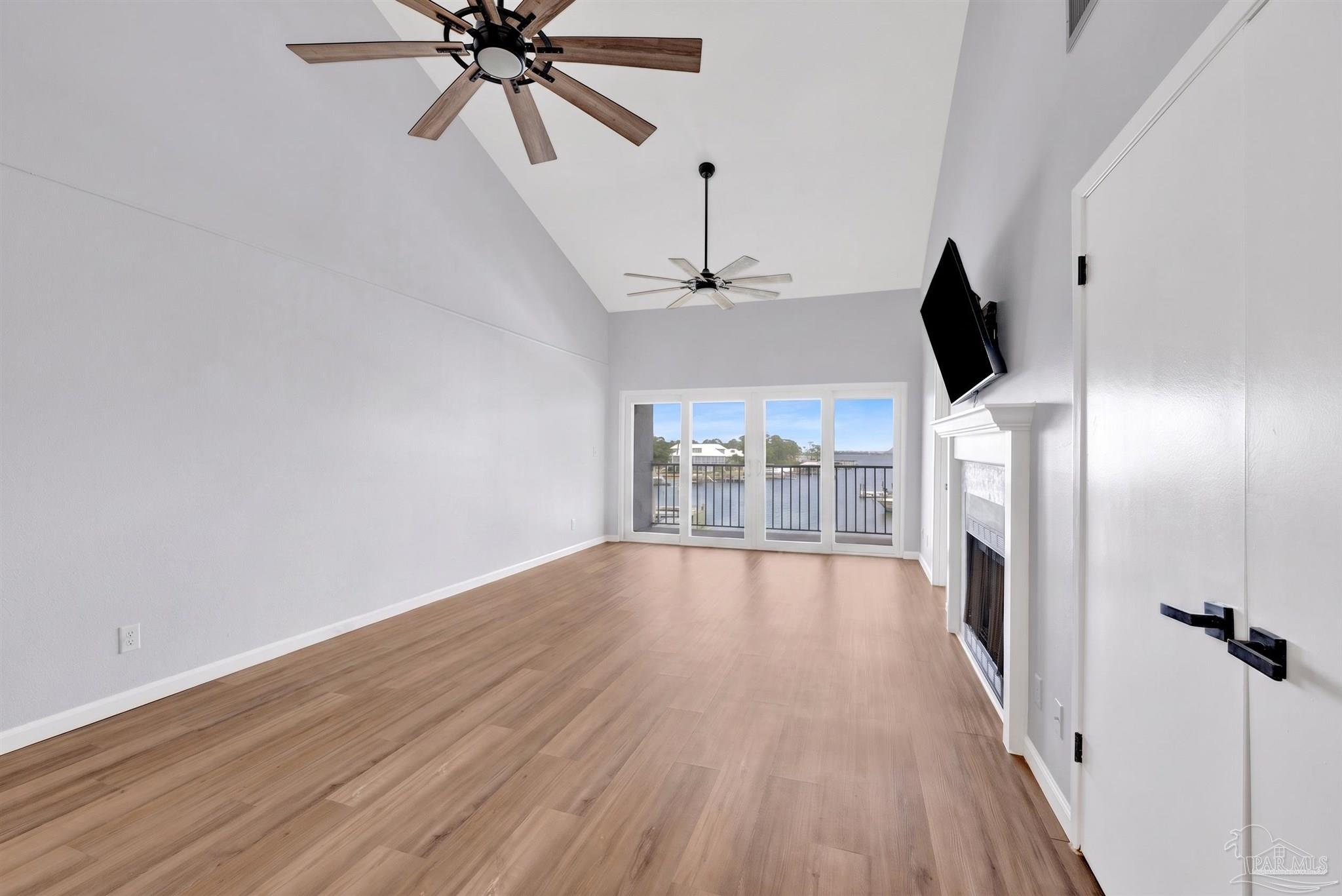 14100 River Road, Unit 334 Perdido Key, FL 32507 - Photo 13 of 35 a view of an empty room with chandelier fan and wooden floor