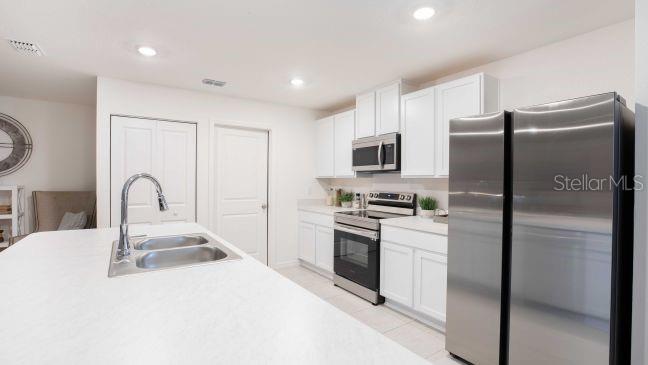 16290 Kakawi Road Weeki Wachee, FL 34614 - Photo 2 of 22 a kitchen with stainless steel appliances granite countertop a refrigerator a stove a sink and a microwave