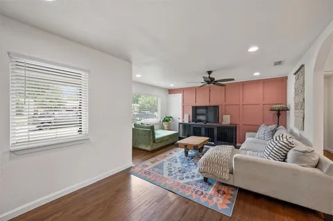 a living room with furniture and a wooden floor