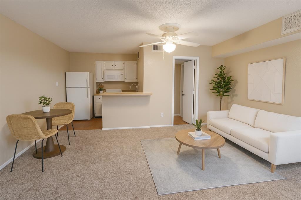 a living room with furniture and kitchen view
