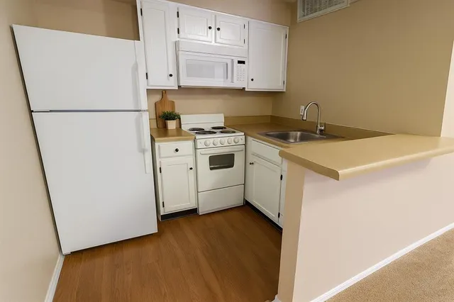 a kitchen with a white cabinets and white appliances