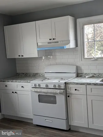 a kitchen with granite countertop white cabinets and white appliances