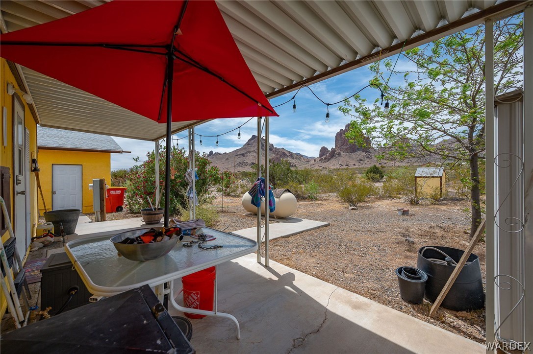 2465 Egar Road Golden Valley, AZ 86413 - Photo 39 of 98 The property includes a covered patio with string lights, providing an outdoor area with views of distant mountains