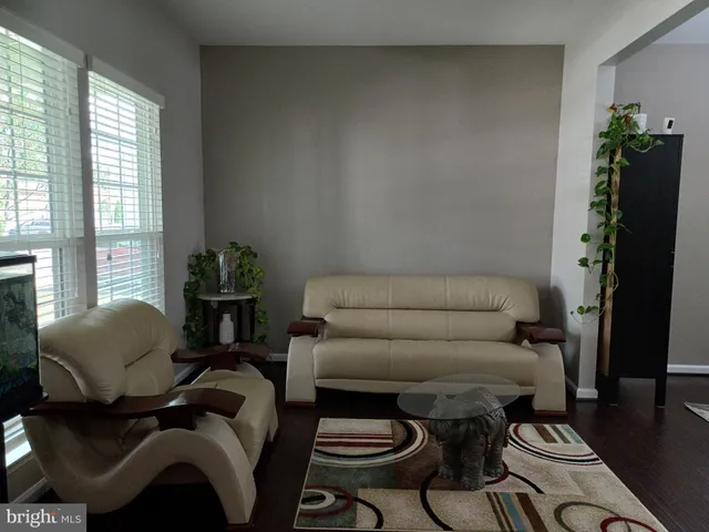 an empty room with wooden floor chandelier and windows