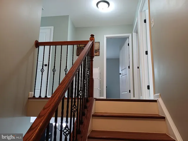 a view of staircase with wooden floor and white walls