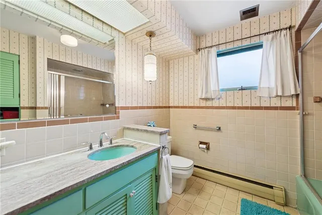 a bathroom with a granite countertop sink mirror vanity and toilet