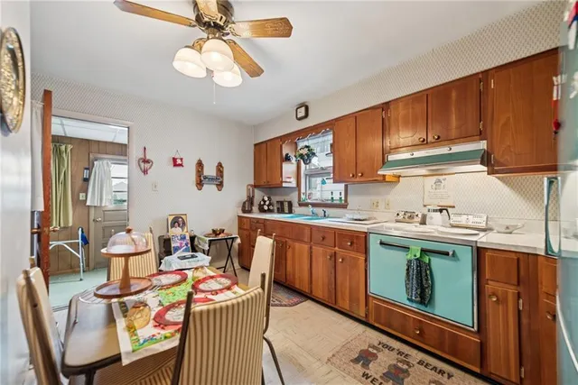 a open kitchen with stainless steel appliances granite countertop a stove top oven a sink dishwasher and cabinets with wooden floor