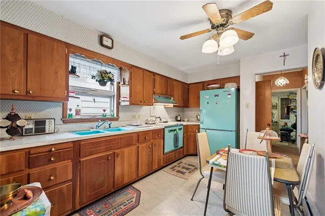a kitchen with stainless steel appliances granite countertop a sink a stove cabinets dining table and chairs