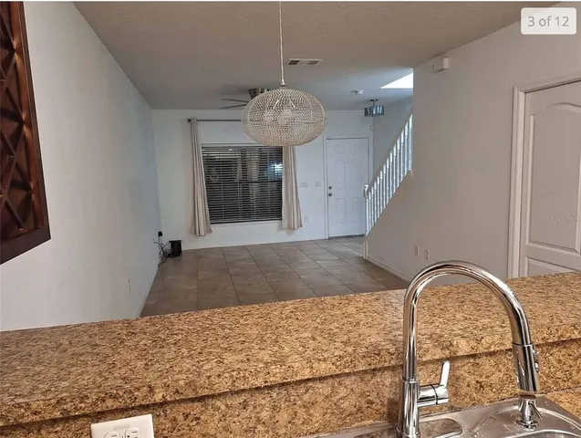 a view of a livingroom with the floor to ceiling windows and kitchen view