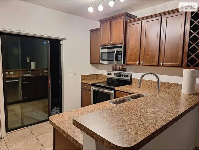 a kitchen with granite countertop a refrigerator a stove and a sink