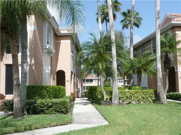 a front view of multi story residential apartment building with yard and green space