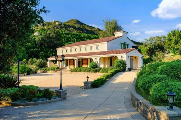 a front view of a house with a yard and potted plants