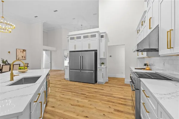 a kitchen with stainless steel appliances a dining table chairs stove and cabinets