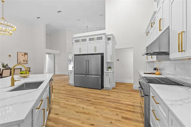 a kitchen with stainless steel appliances a dining table chairs stove and cabinets