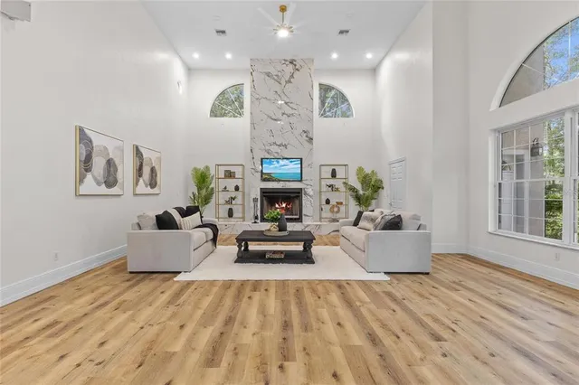 a living room with furniture a fireplace and a large window