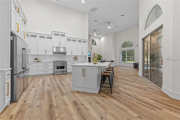 a kitchen with stainless steel appliances a stove top oven a sink refrigerator and cabinets