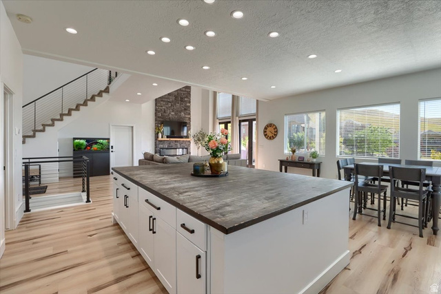 828 South Deer Road Tooele, UT 84074 - Photo 7 of 51 Spacious kitchen island with white cabinetry and dark countertop, complemented by light wood-finish flooring
