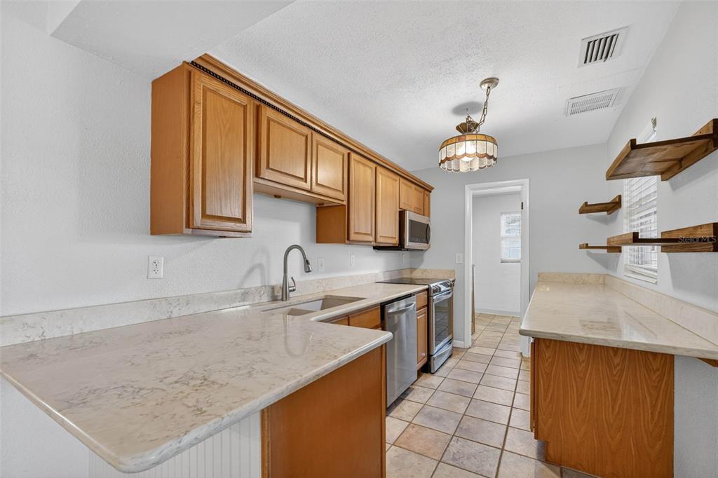 309 North 8th Street Dundee, FL 33838 - Photo 16 of 91 a kitchen with stainless steel appliances granite countertop a sink stove and refrigerator