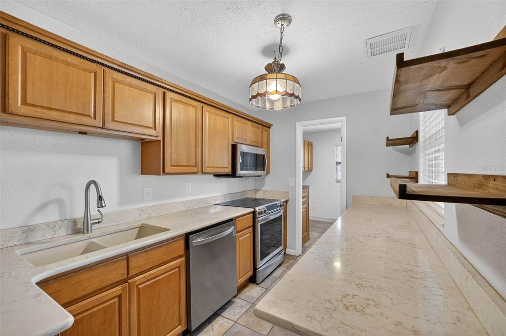 309 North 8th Street Dundee, FL 33838 - Photo 18 of 91 a kitchen with stainless steel appliances granite countertop a sink dishwasher and a stove with wooden floor