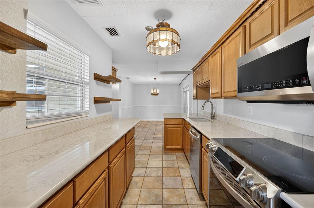 309 North 8th Street Dundee, FL 33838 - Photo 19 of 91 a kitchen with stainless steel appliances granite countertop a sink and a stove