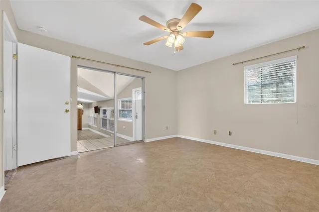 a view of an empty room with a chandelier fan