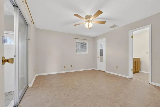 an empty room with closet and a ceiling fan