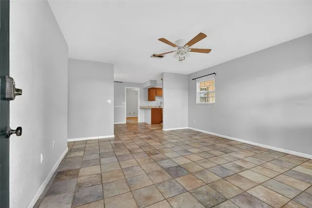 a living room with furniture and three windows