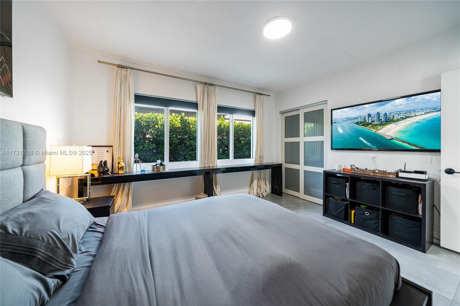 835 Fairway Drive Miami Beach, FL 33141 - Photo 30 of 39 a bedroom with a bed and a flat tv screen on dresser