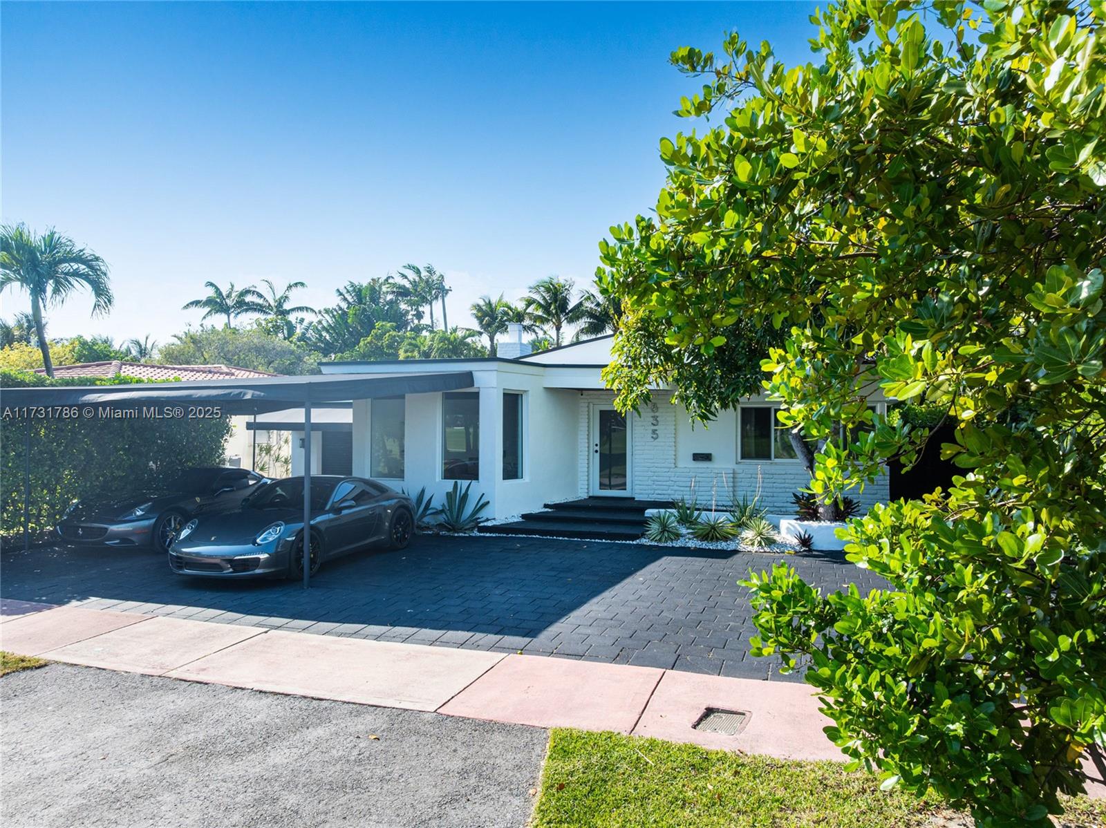 835 Fairway Drive Miami Beach, FL 33141 - Photo 3 of 39 a front view of a house with a yard and potted plants