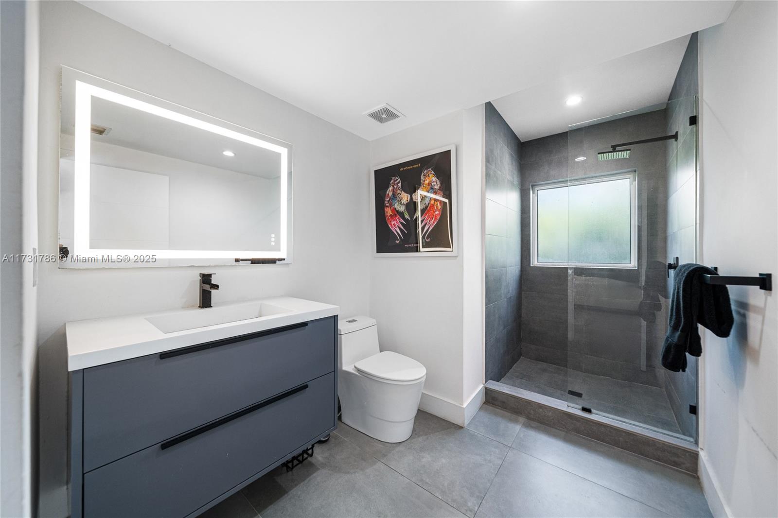 835 Fairway Drive Miami Beach, FL 33141 - Photo 31 of 39 a bathroom with a toilet sink and mirror