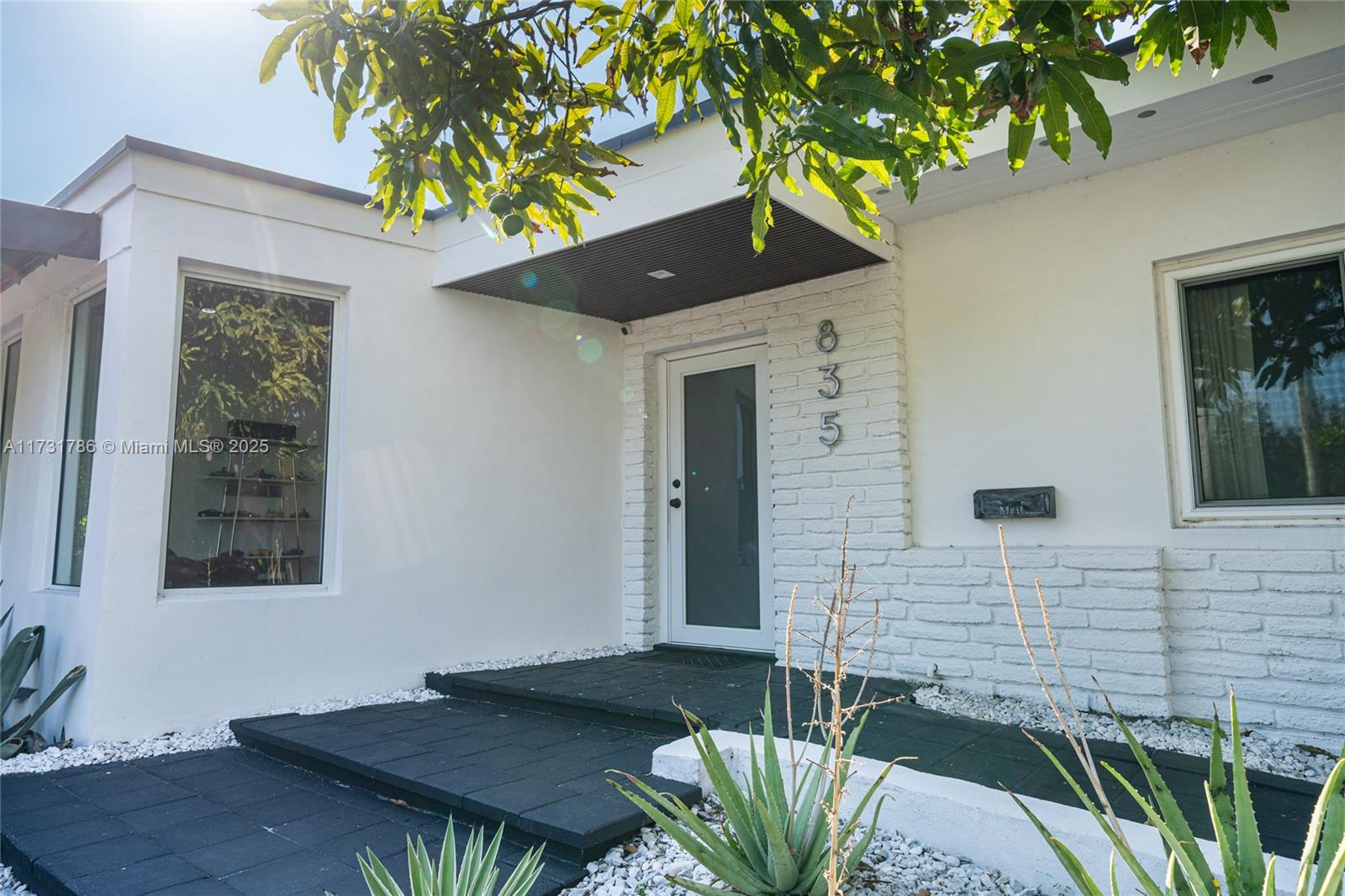 835 Fairway Drive Miami Beach, FL 33141 - Photo 4 of 39 a front view of a house with a garden