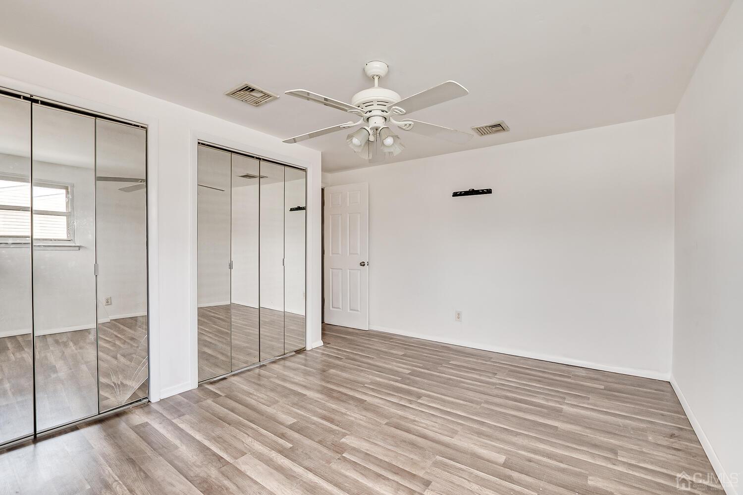 62 Hickory Road Colonia, NJ 07067 - Photo 15 of 23 an empty room with wooden floor fan and windows