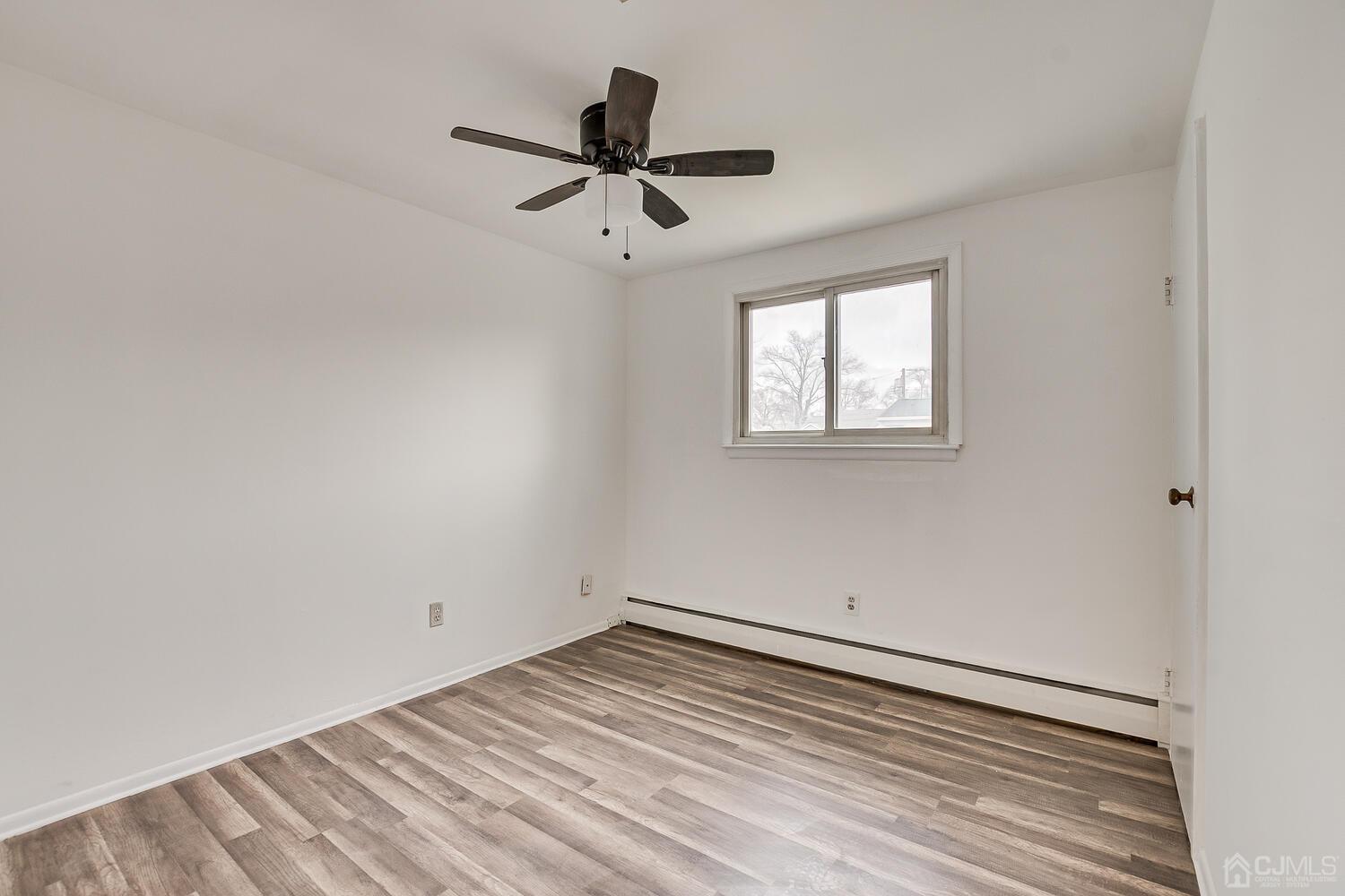 62 Hickory Road Colonia, NJ 07067 - Photo 19 of 23 a view of empty room with wooden floor and fan