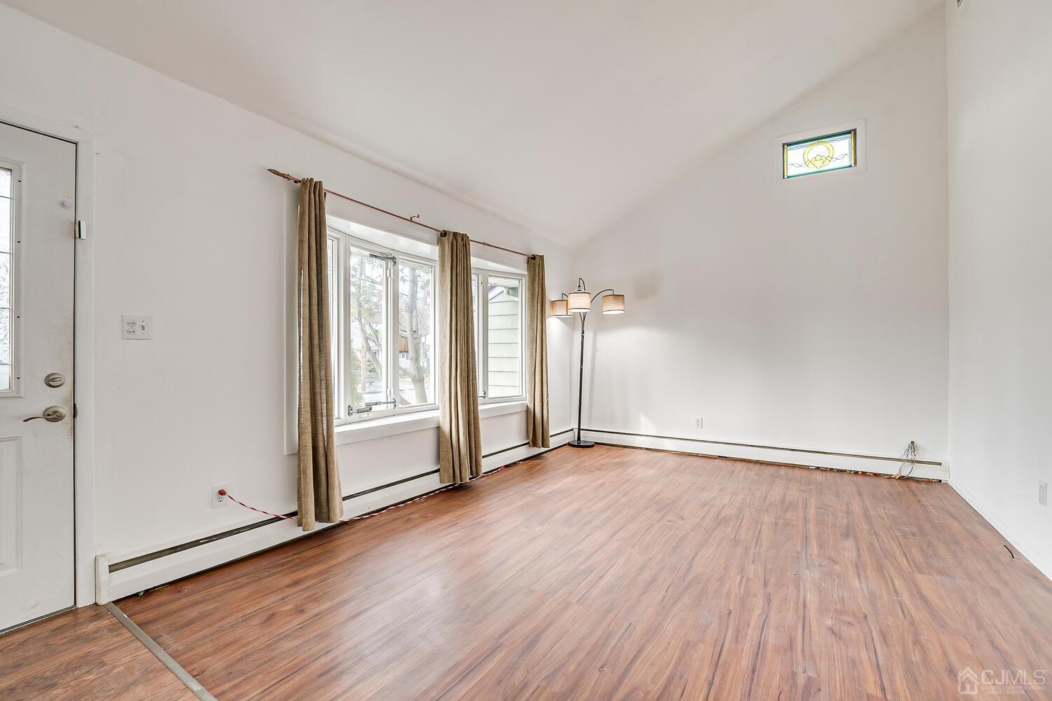 62 Hickory Road Colonia, NJ 07067 - Photo 4 of 23 an empty room with wooden floor and windows