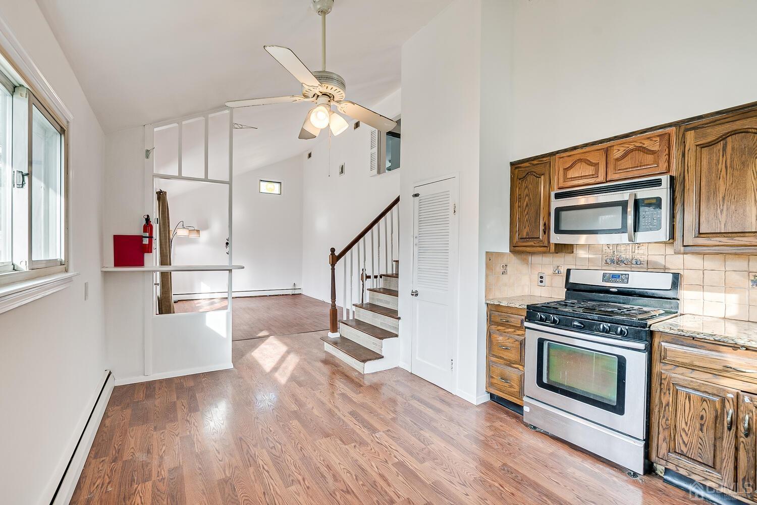 62 Hickory Road Colonia, NJ 07067 - Photo 8 of 23 a kitchen with granite countertop a stove and a wooden floor