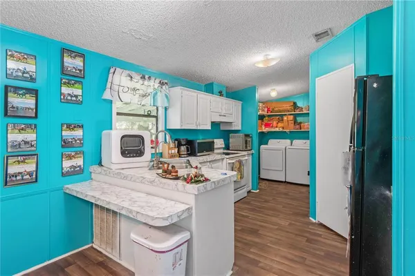a kitchen with stainless steel appliances granite countertop a refrigerator a stove and a wooden floor