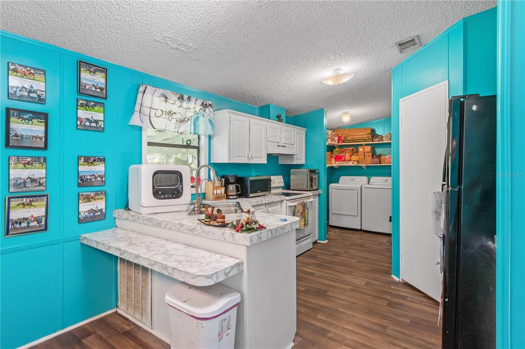 8081 Southwest 41st Place Road Ocala, FL 34481 - Photo 13 of 50 a kitchen with stainless steel appliances granite countertop a refrigerator a stove and a wooden floor