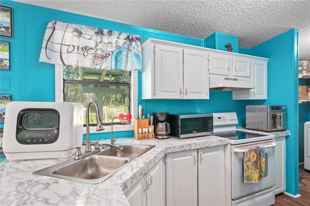 8081 Southwest 41st Place Road Ocala, FL 34481 - Photo 15 of 50 a kitchen with stainless steel appliances granite countertop a sink and a stove next to a refrigerator