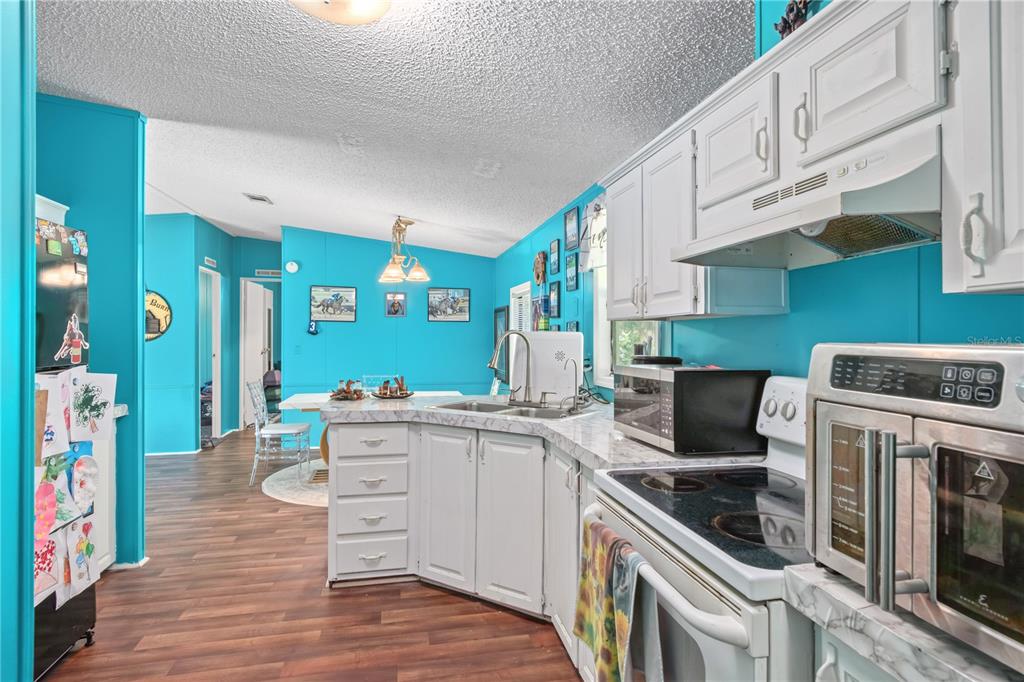 8081 Southwest 41st Place Road Ocala, FL 34481 - Photo 16 of 50 a kitchen with a sink cabinets and wooden floor