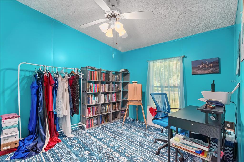 8081 Southwest 41st Place Road Ocala, FL 34481 - Photo 27 of 50 a view of a workspace with furniture and a book shelf