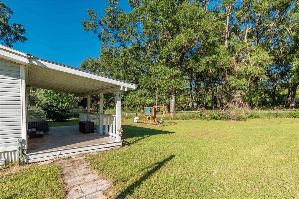 8081 Southwest 41st Place Road Ocala, FL 34481 - Photo 30 of 50 a view of a patio with table and chairs under an umbrella