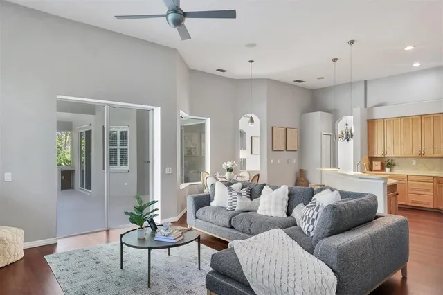 a living room with furniture kitchen view and a window