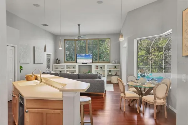 a kitchen with granite countertop a table chairs stove and sink