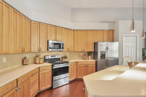 a kitchen with stainless steel appliances a stove a sink a refrigerator and cabinets