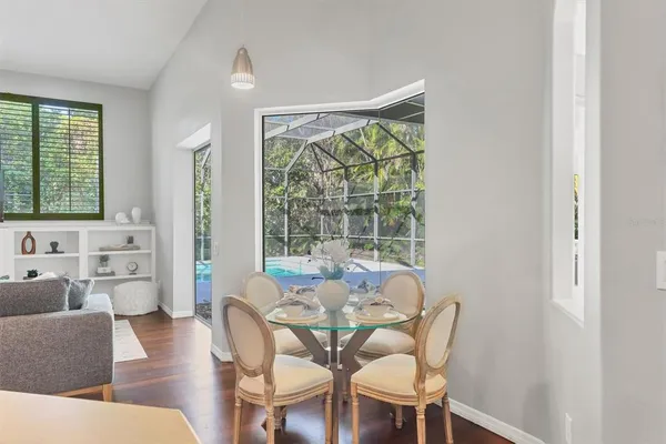 a dining room with furniture and large windows